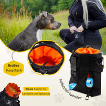 Kleiner Futterbeutel von Hundefreund in Schwarz-Orange, Hund nimmt ein Leckerli